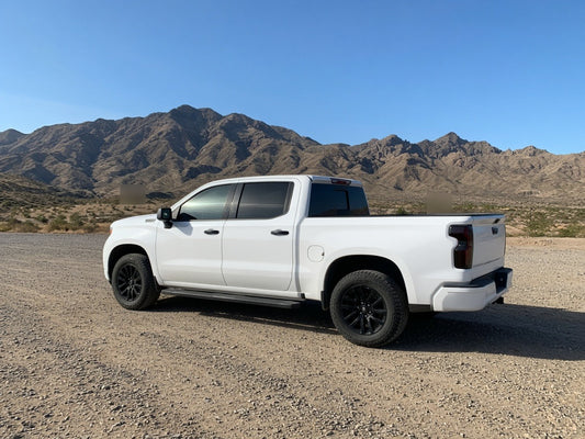 Chrome delete window trim wrapped in black film on a white pickup truck