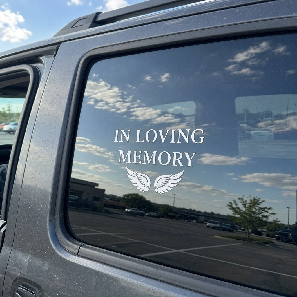 White In Loving Memory vinyl decal with wings installed on an SUV rear window
